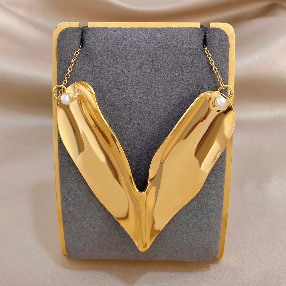 Gold-tone irregular heart pendant necklace with two faux pearl drops on chain