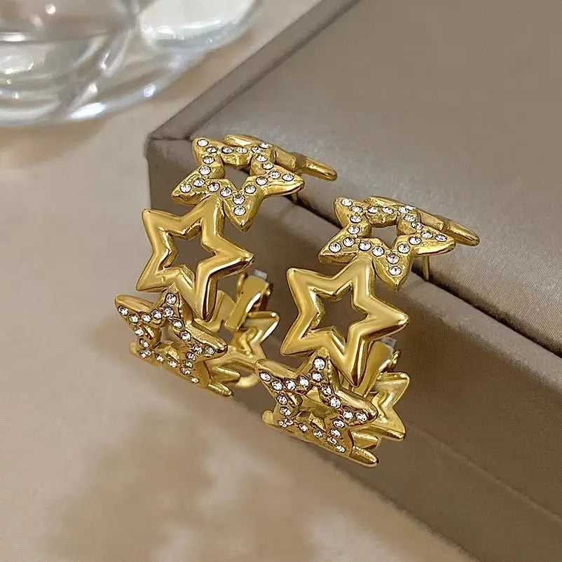 Gold-tone star hoop earrings with hollow stars and rhinestone-set accents