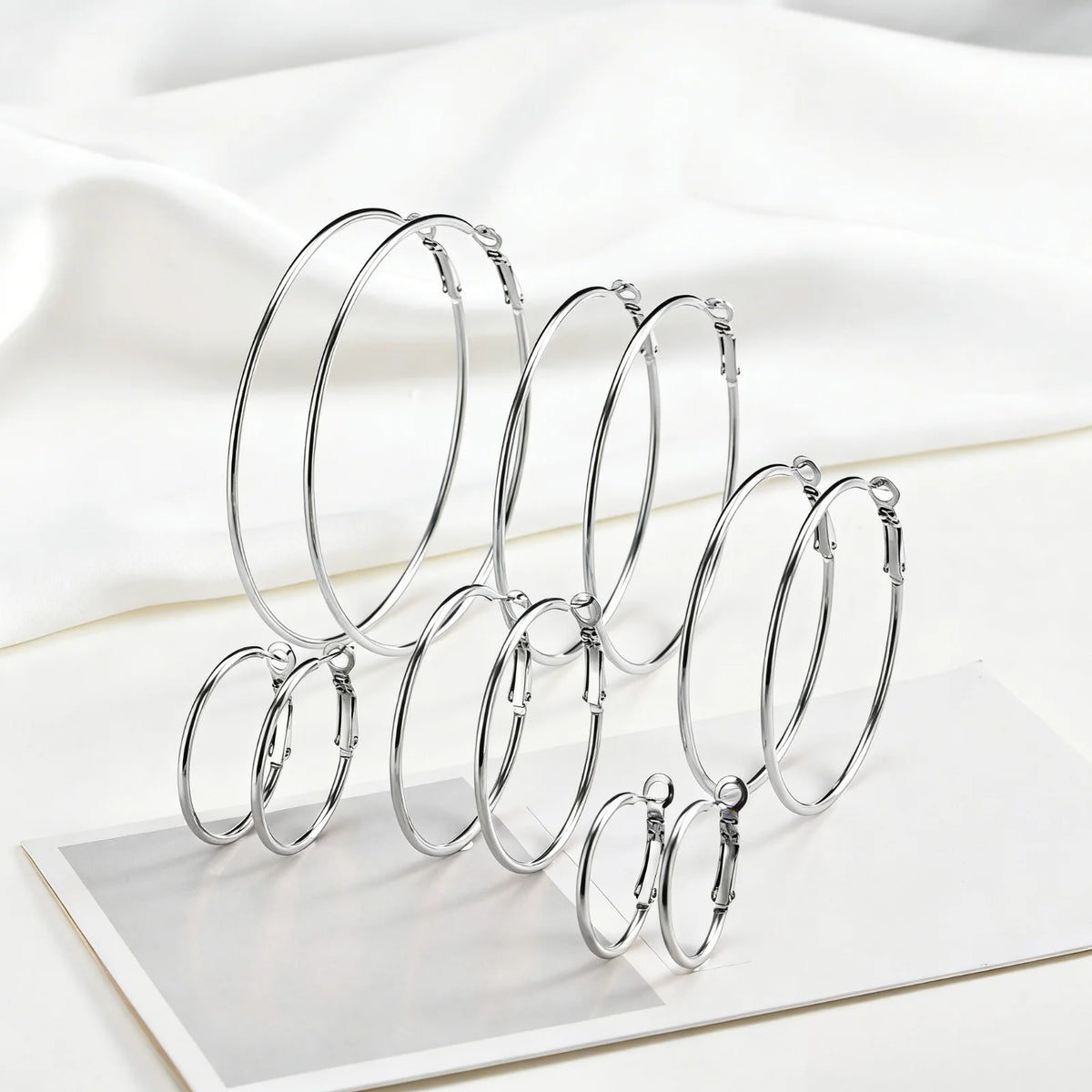 Silver-tone hoop earrings in six sizes, arranged upright.
