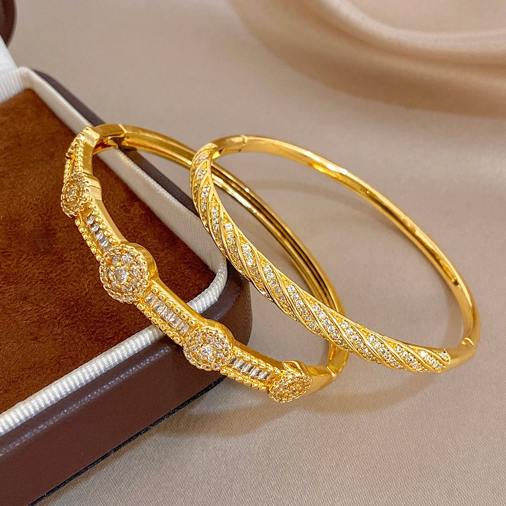 Gold-tone crystal inlay bangles with textured segments, angled close-up