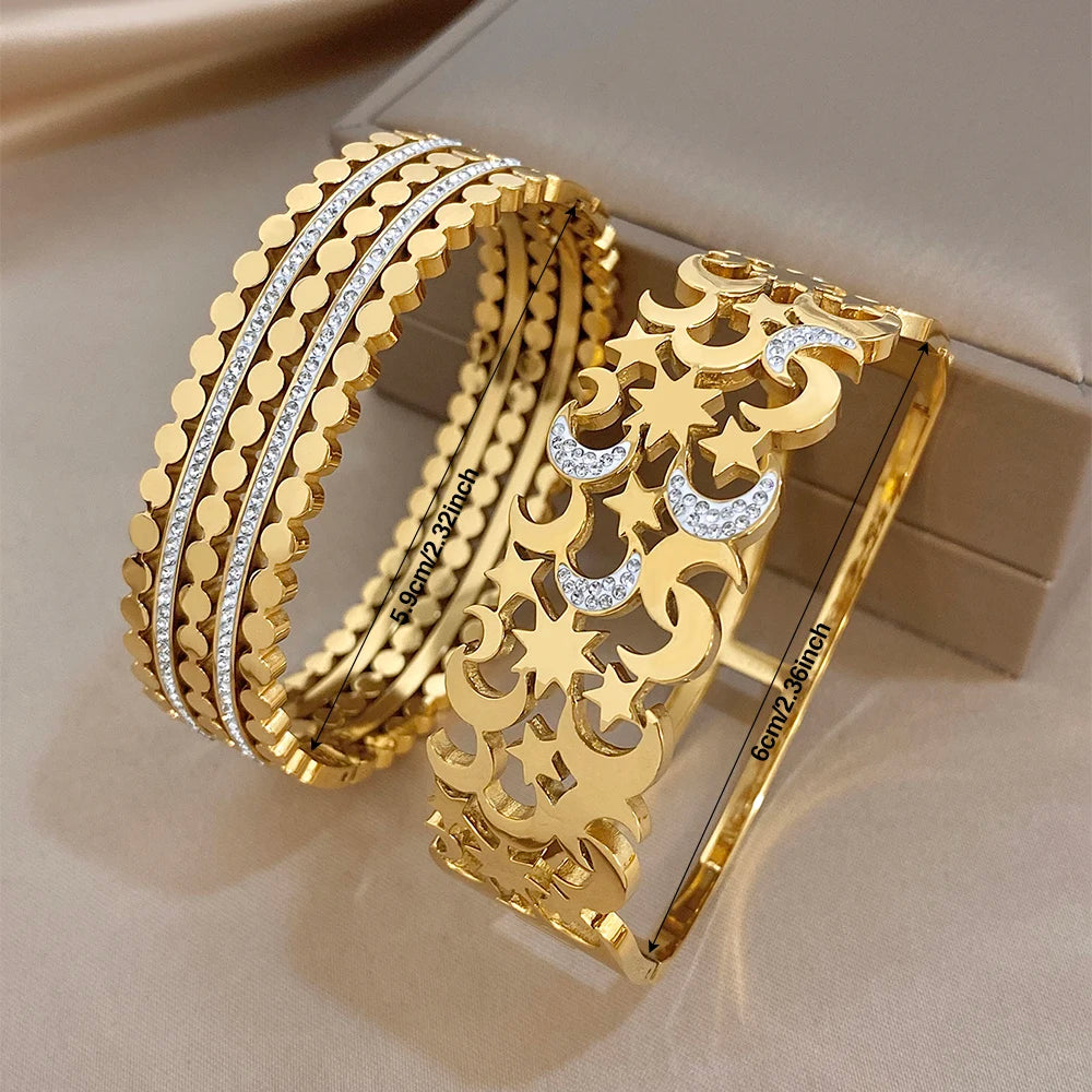 Wide gold-tone cuff bracelet set with star and crescent cutouts, crystal-filled details