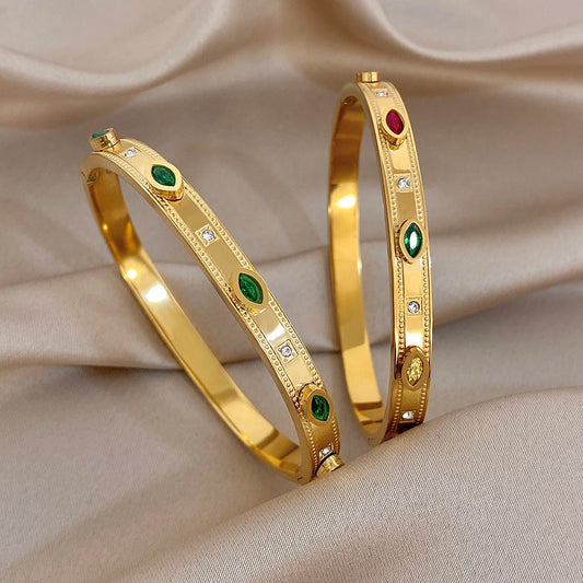 Gold-tone bangle with green and red oval stones, clear rhinestone accents