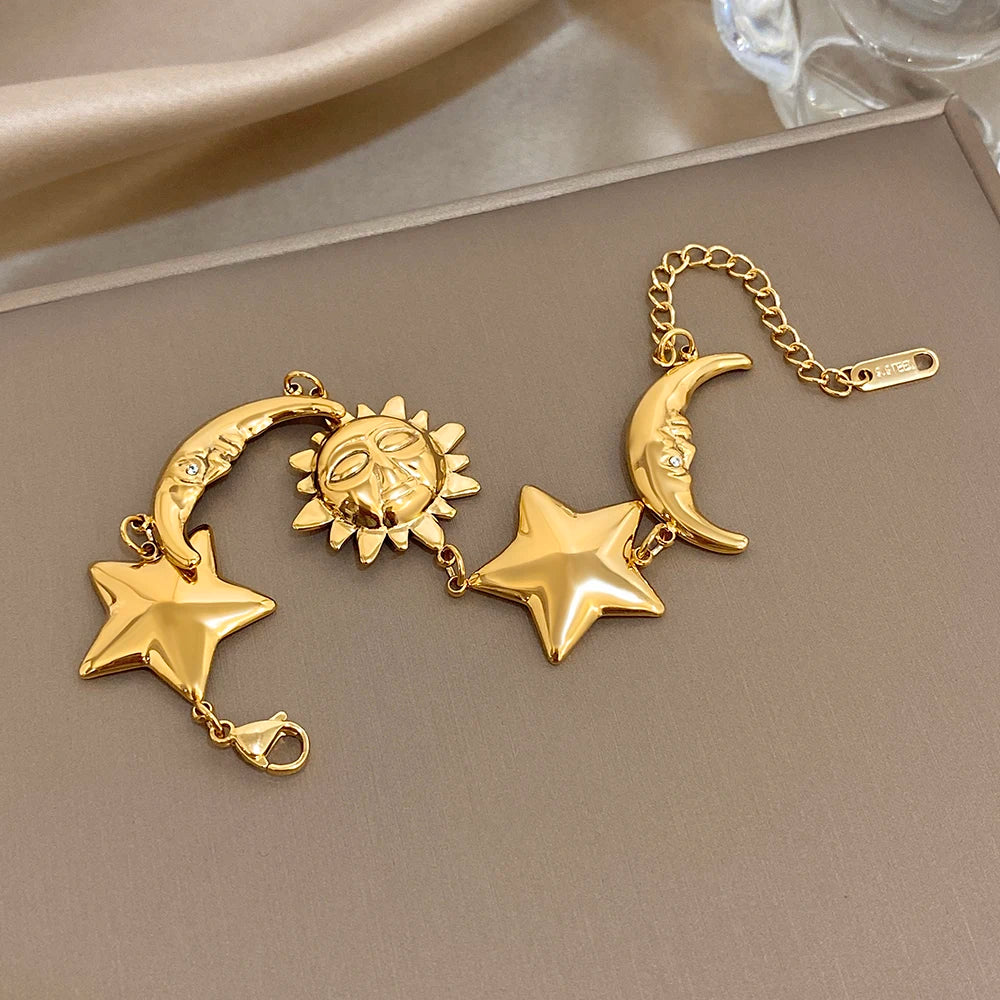 Gold-tone charm bracelet with star, crescent moon, and sun charms, chain and clasp