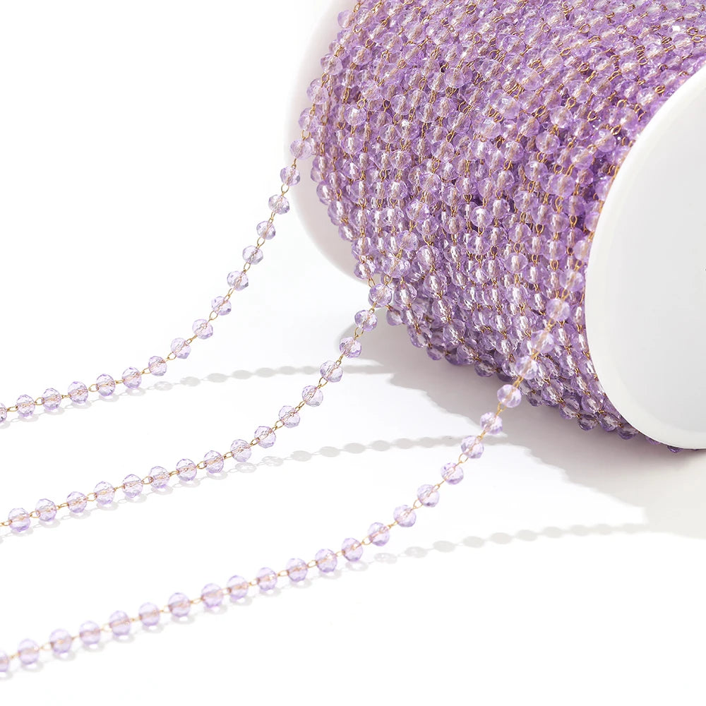 Light purple faceted beaded chain on a white spool with dangling strands