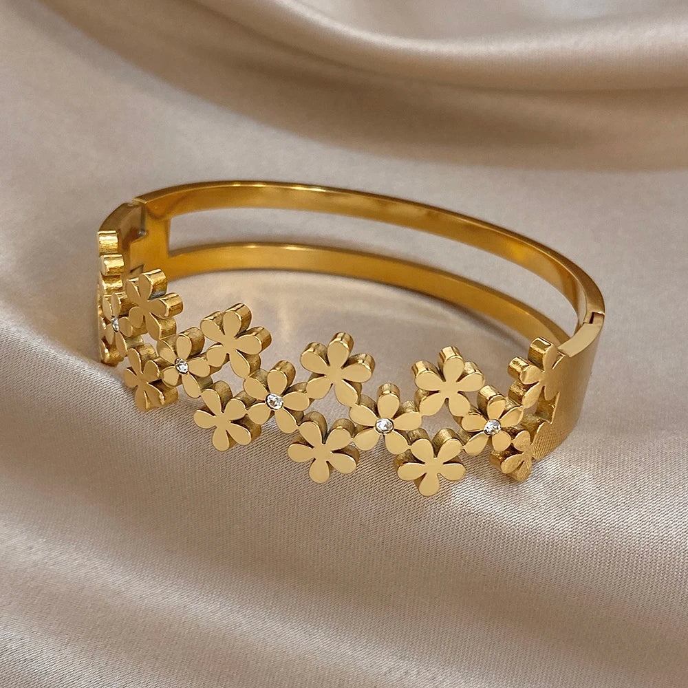 Gold-plated wide cuff bangle with flower garland detail and crystal dots
