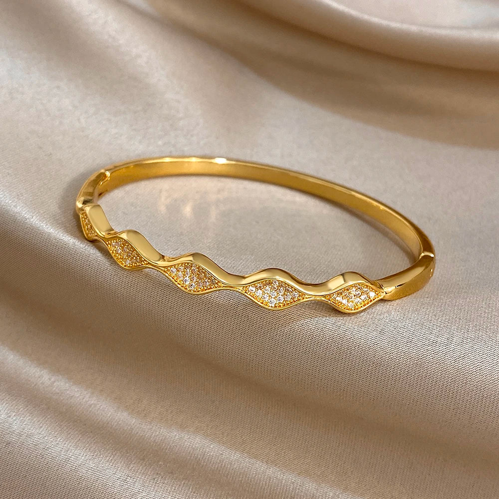 Gold-plated wave bangle bracelet with raised glitter stone pattern
