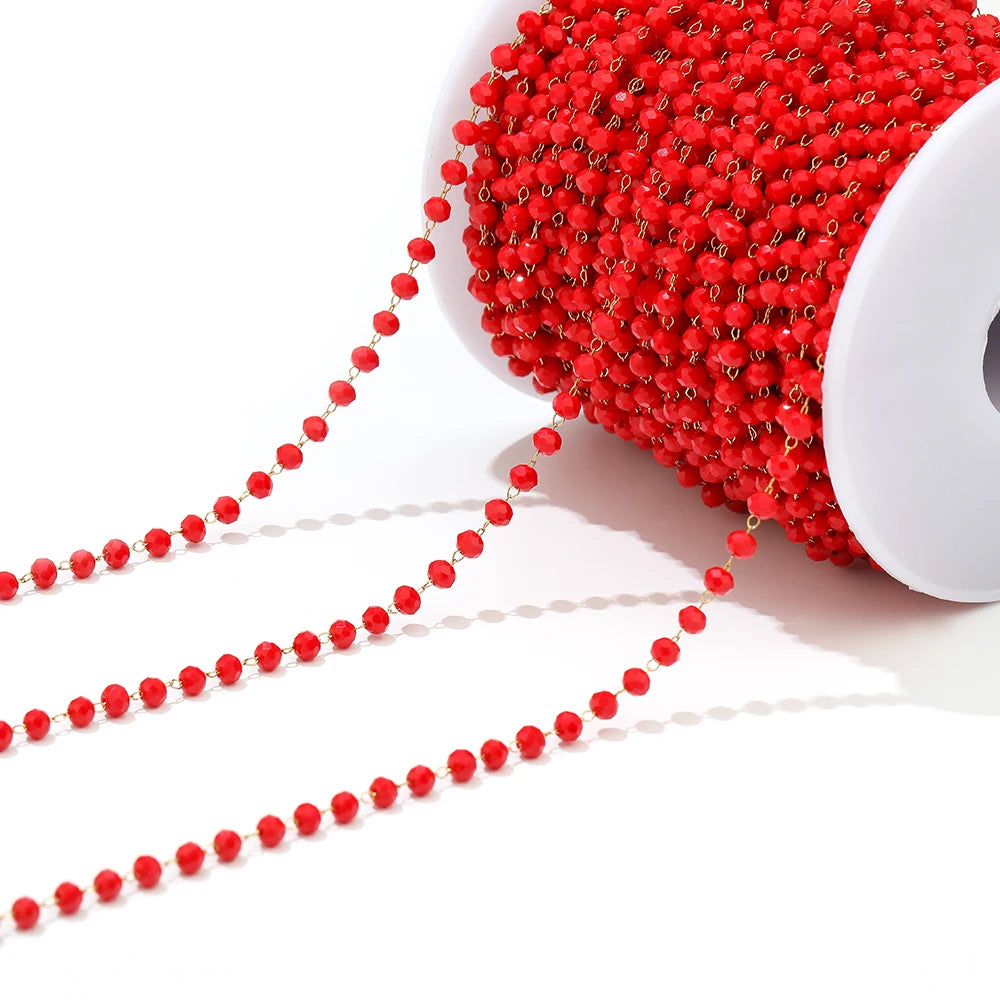 Red faceted beaded chain on a white spool with two loose strands