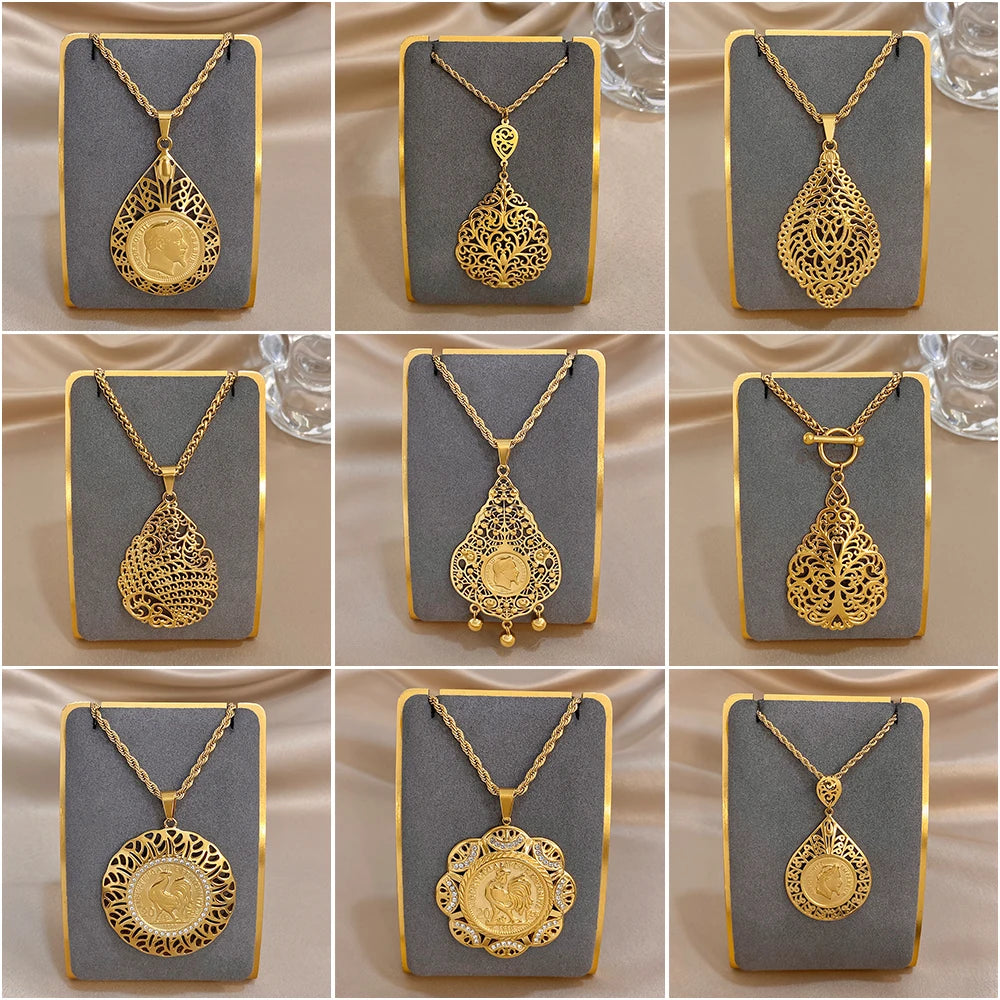 Gold-tone necklace pendants with ornate hollow flower and teardrop charms on display cards