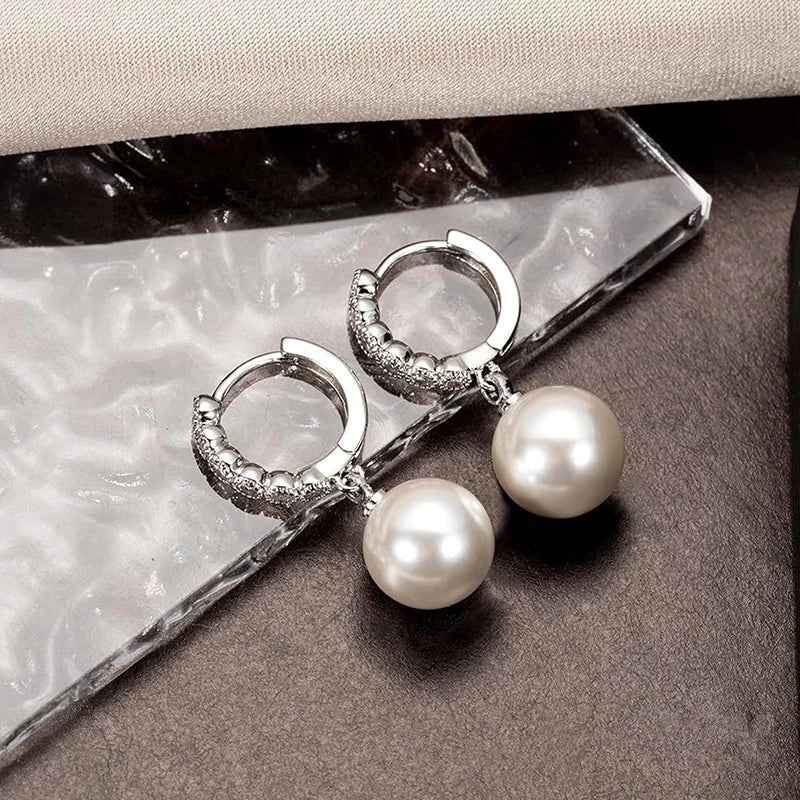 Silver-tone zirconia hoop earrings with round pearl drops, close-up