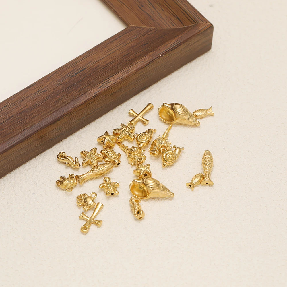 Gold-toned marine animal charm assortment, including elephant, shell, starfish and cross