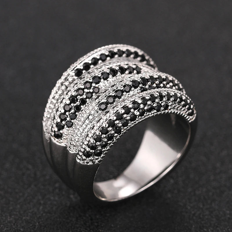 Silver-tone statement ring with a curved, multi-row band of black and clear stones
