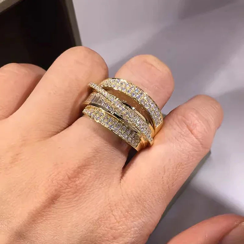 Gold-tone CZ cross-over open band ring with layered sparkle rows on finger
