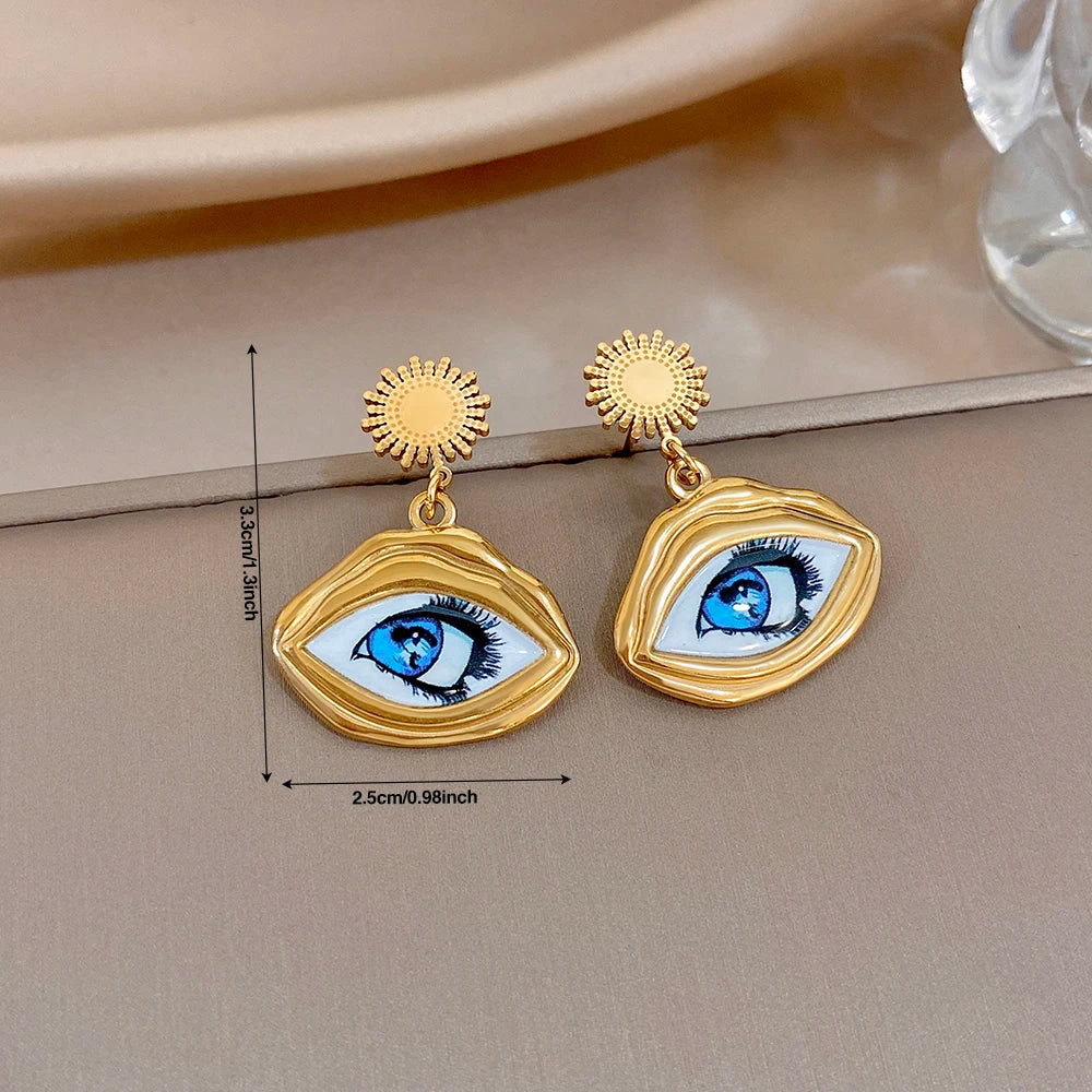 Gold-tone evil eye earrings with sunburst tops and oval eye charms; size shown