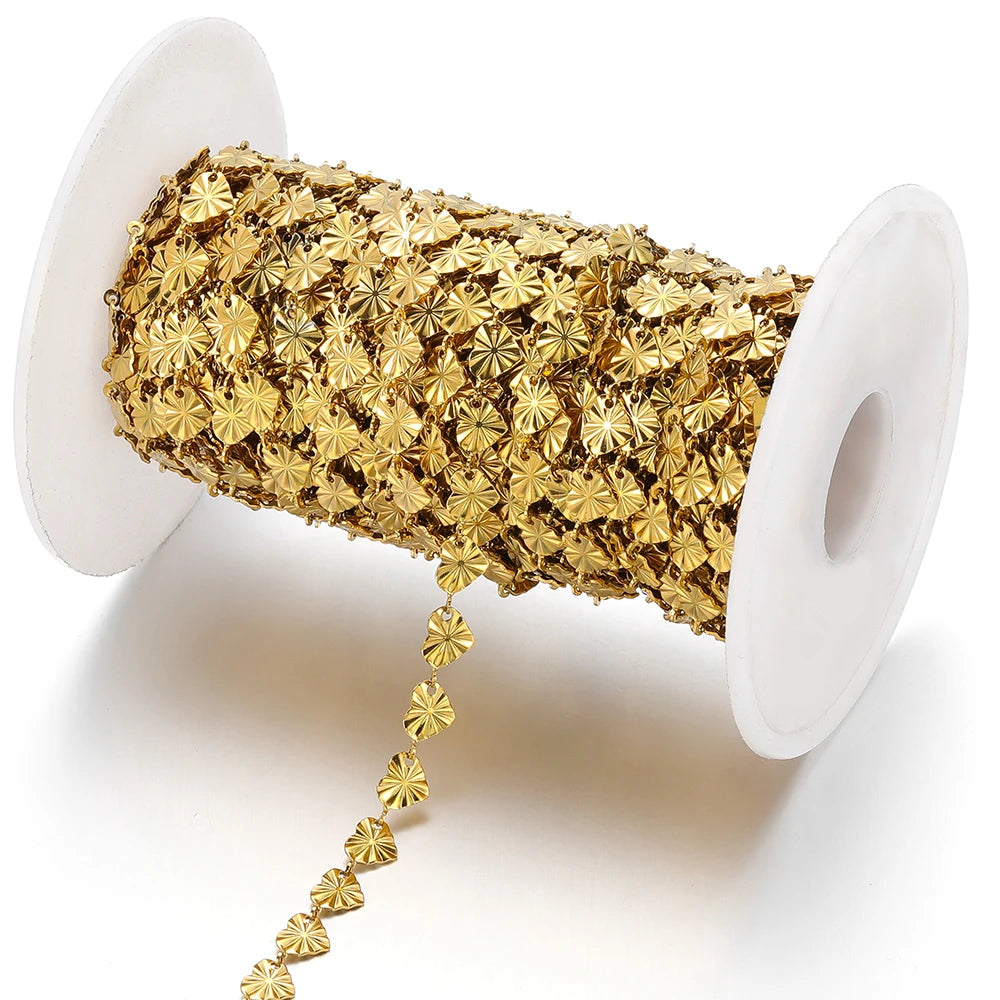 Gold-tone heart-shaped embossed link chain extending from a white spool