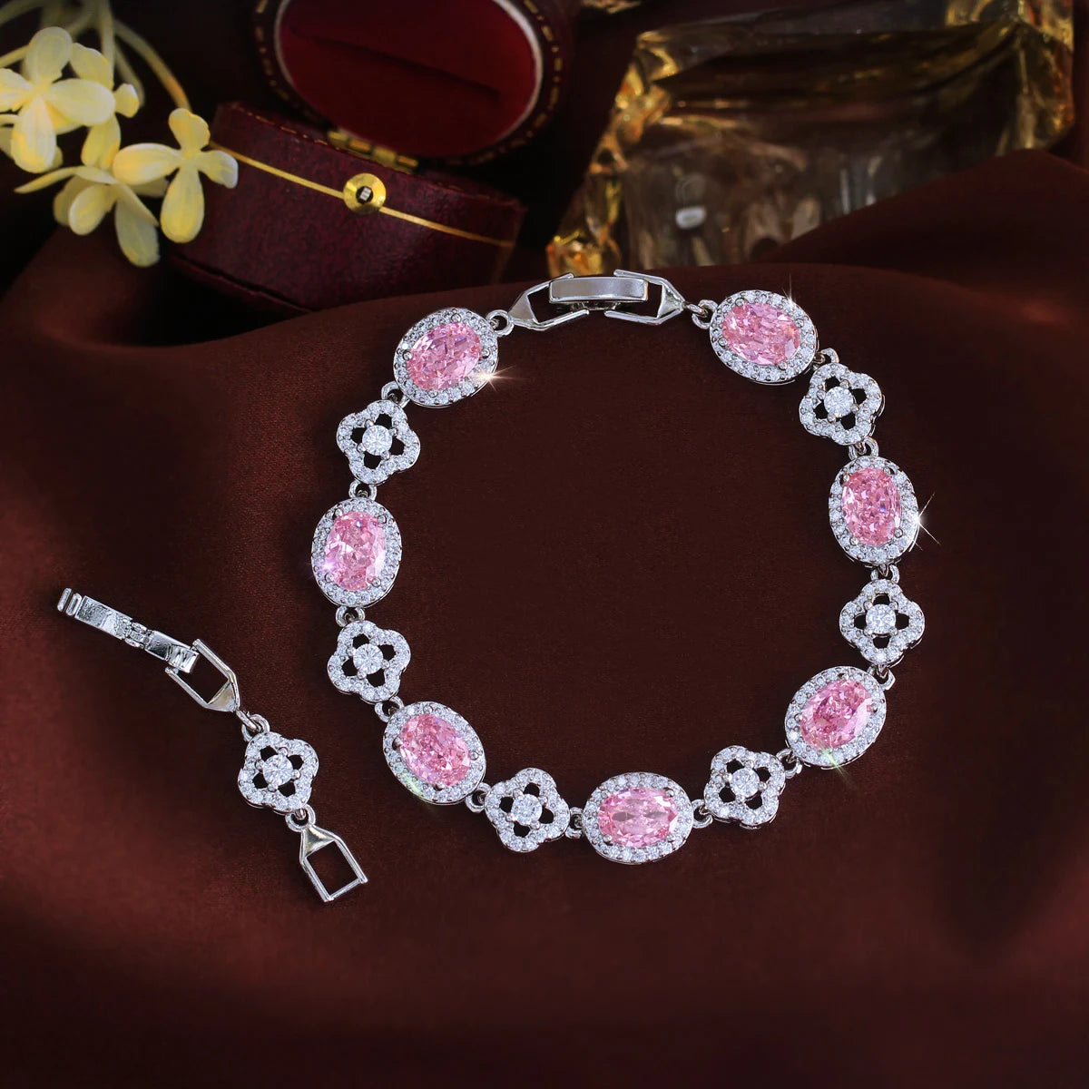 Pink oval crystal flower tennis bracelet arranged in a circle with clasp