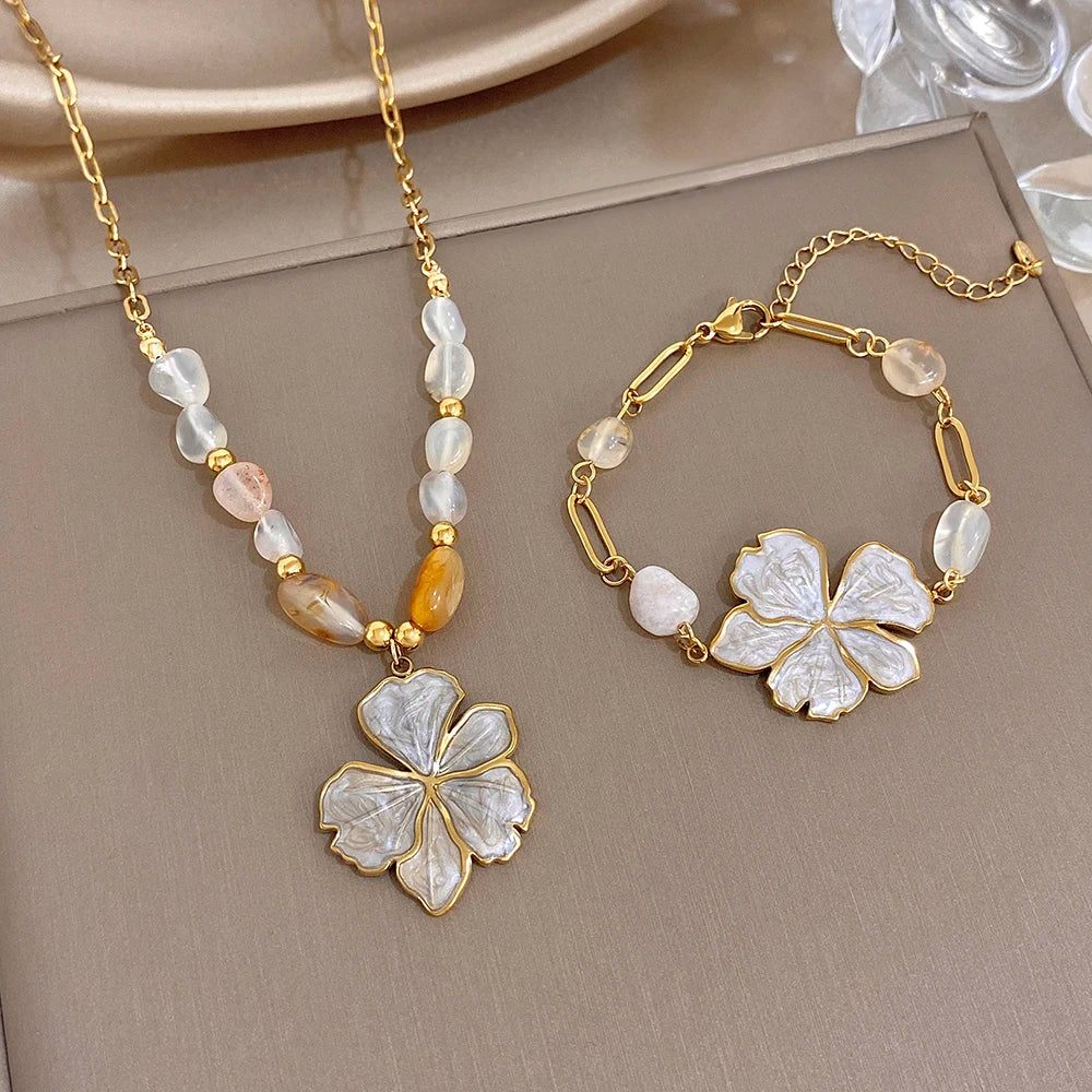 Gold plated bracelet set with light and amber beads and white enamel flower charms