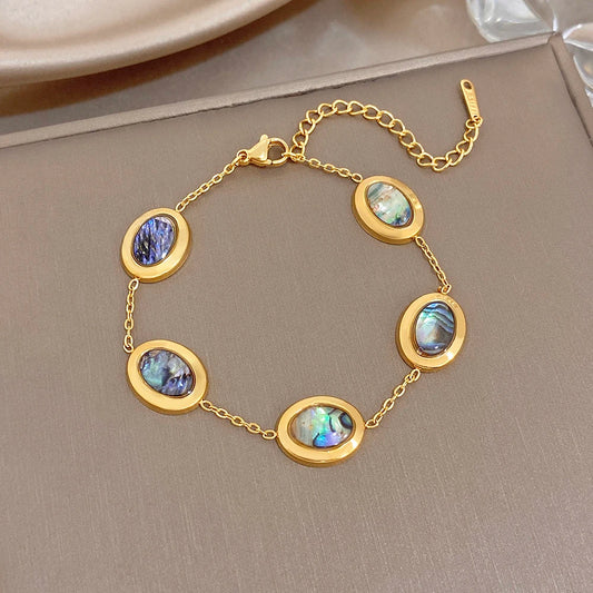 Gold plated oval chain bracelet with blue and iridescent abalone shell discs