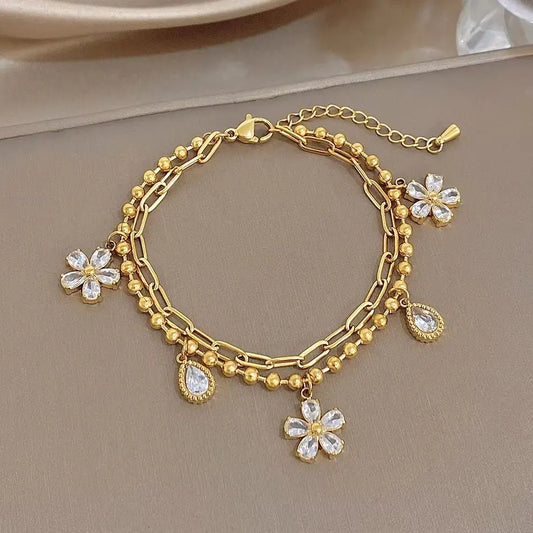 Gold-plated chain bracelet with dangling crystal flower and teardrop charms