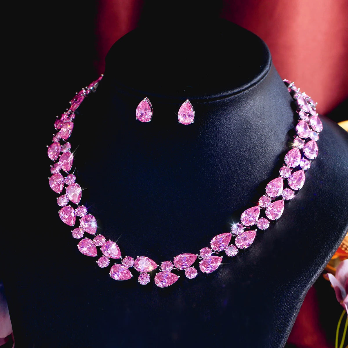 Pink teardrop rhinestone necklace with matching stud earrings on black bust
