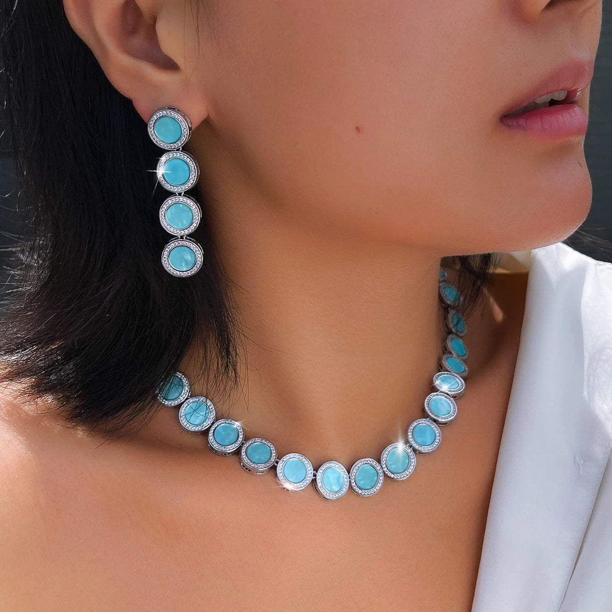 Light blue enamel halo necklace and matching drop earrings, shown close up