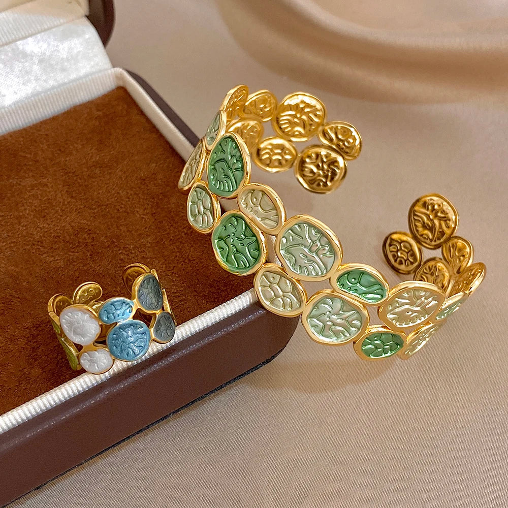 Gold-tone enamel leaf coin cuff bracelet with green highlights and blue accent coins