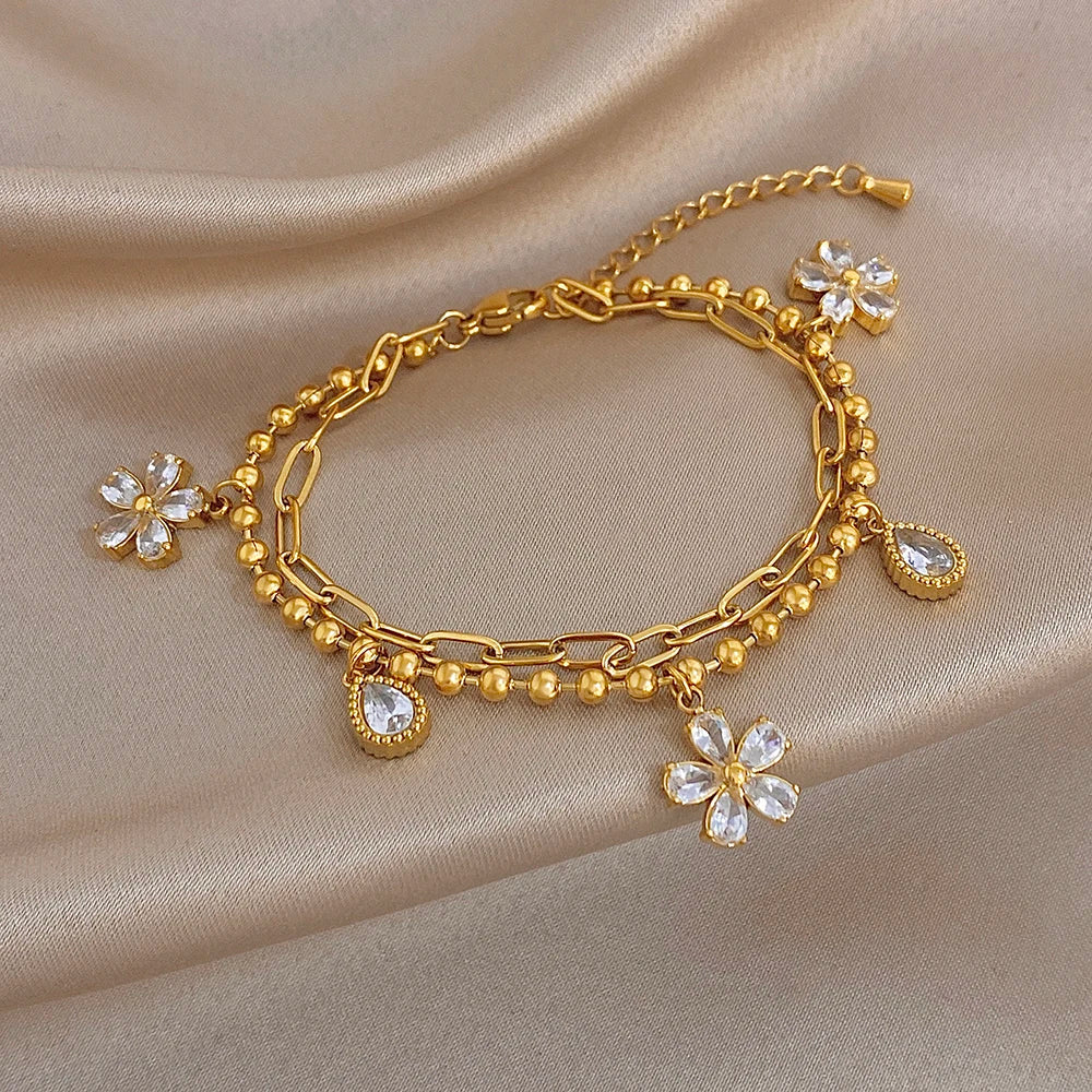 Gold-tone chain bracelet with crystal flower charms and teardrop crystal drops