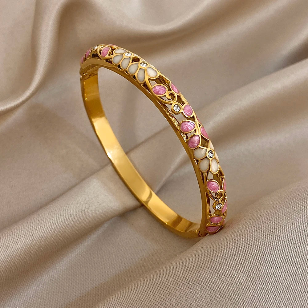 Gold-plated cuff bangle with purple and white enamel flower design and crystal accents