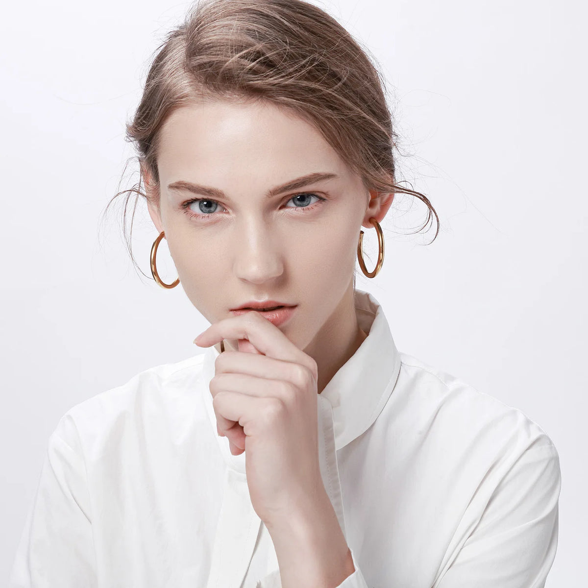 Gold chunky hoop earrings worn on a model