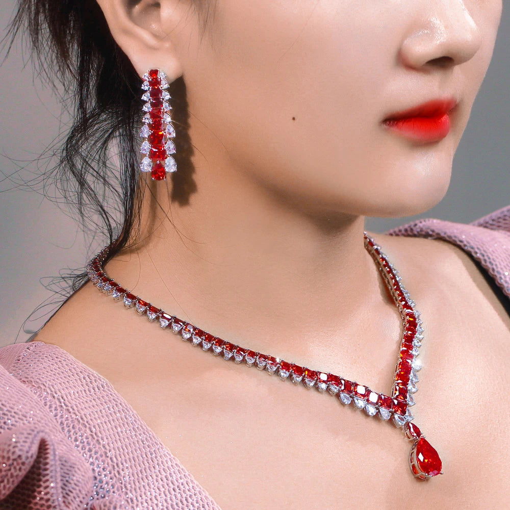 Red cubic zirconia necklace and drop earring worn, showing the V-shaped chain and pendant