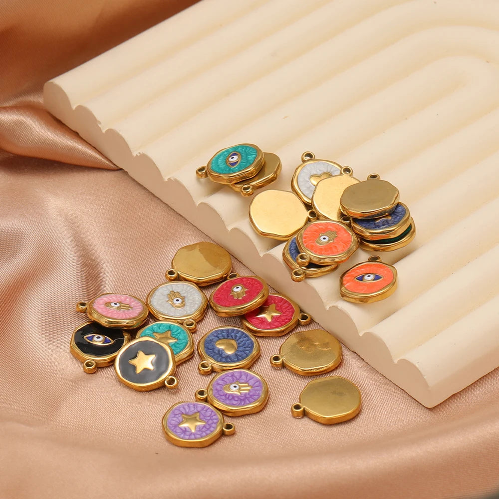 Assorted enamel evil eye charm pendants with gold frames on folded fabric