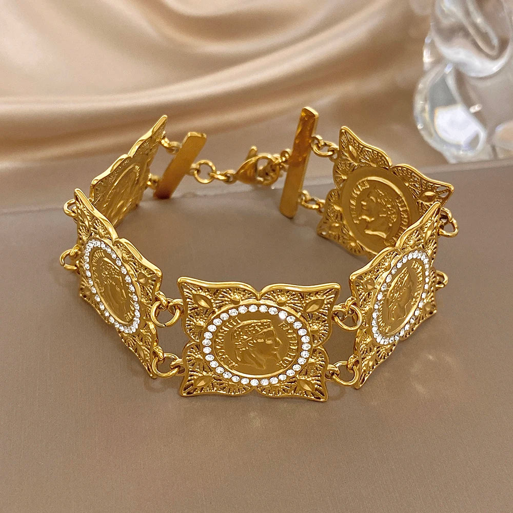 Gold-tone coin rhinestone bracelet with repeating oval medallions and sculpted side links