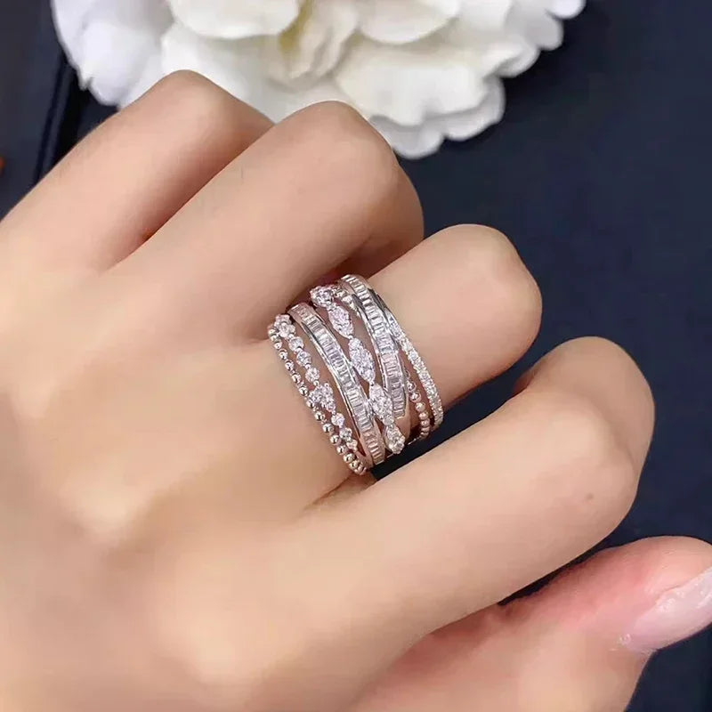 Silver multi-band cubic zirconia ring on finger, featuring rows of small round stones