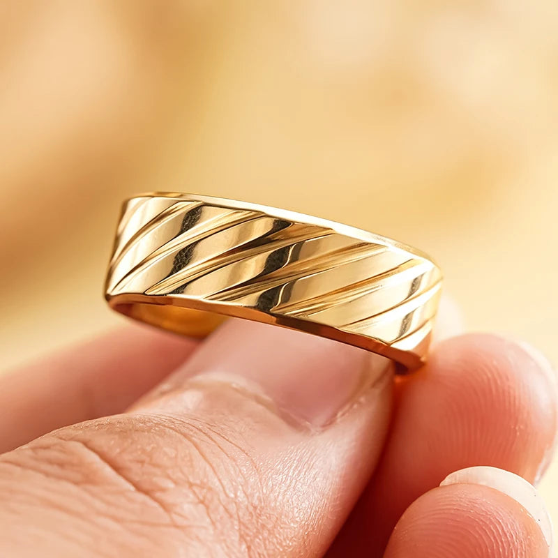 Gold-tone diagonal groove band ring with angled ridges and mirror-like shine