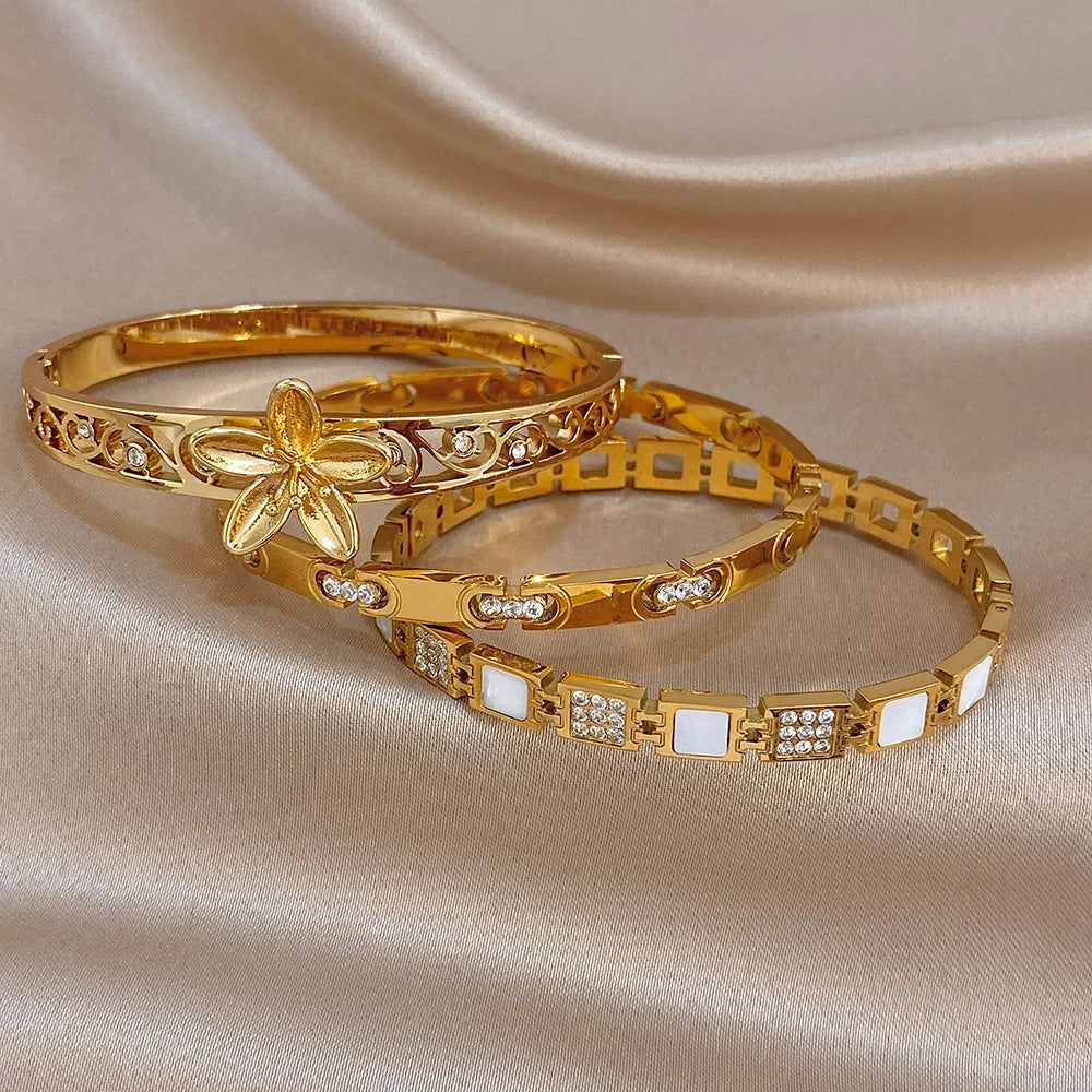 Gold-plated flower cuff bangle with geometric cutouts and square crystal accents