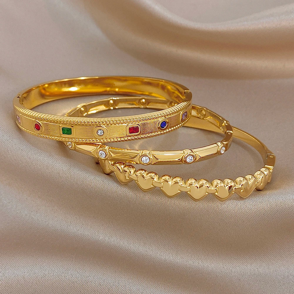 Stacked gold-tone bangles with red, green, and blue stones and clear rhinestone accents
