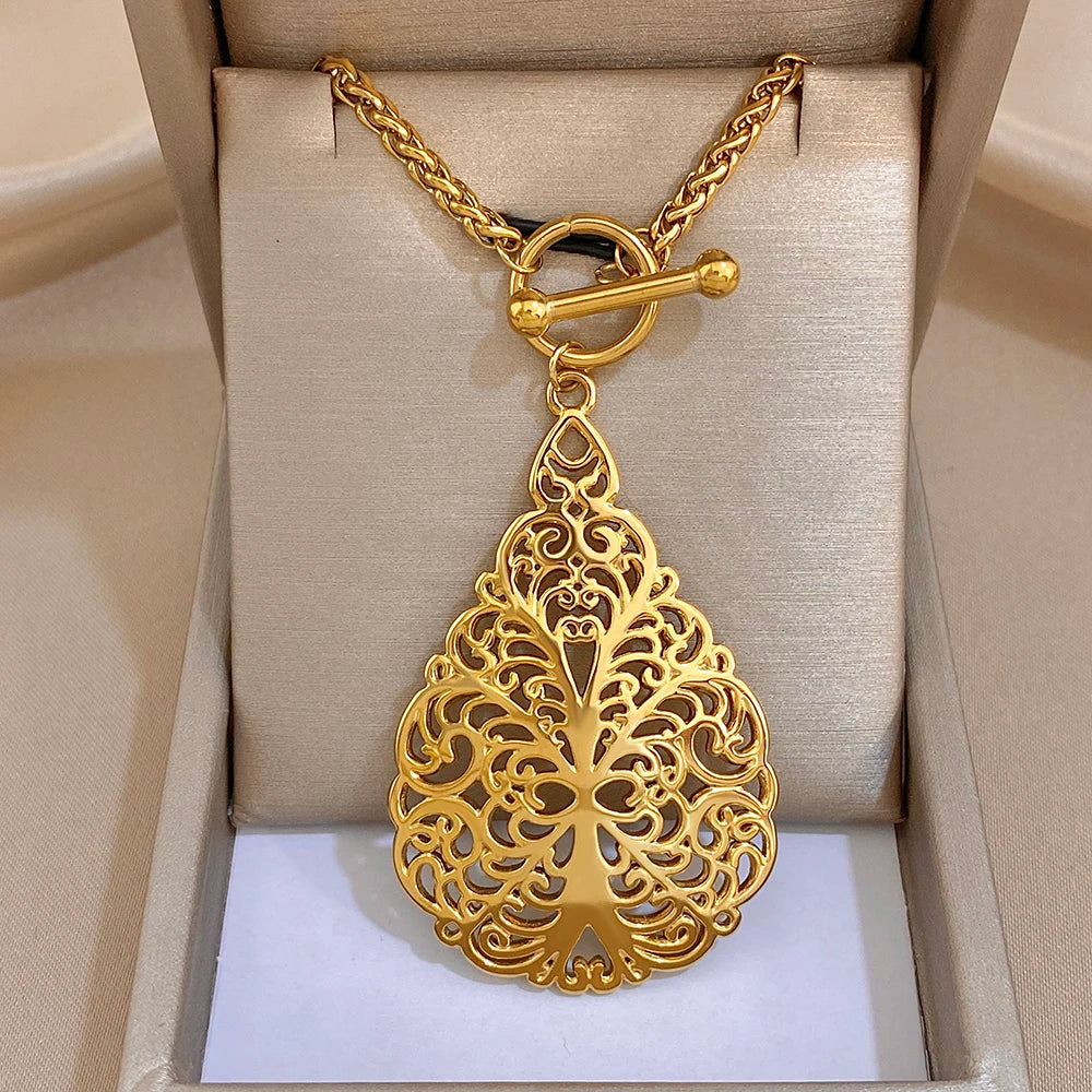 Gold-tone waterdrop floral filigree pendant necklace with central crest detail