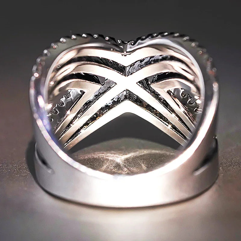Underside view of silver-tone openwork rhinestone cross ring with prong details