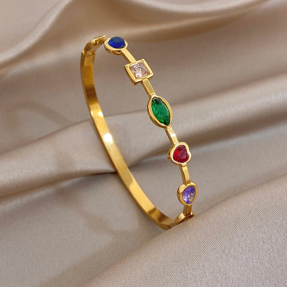 Gold-tone geometric bangle bracelet with blue, green, red, and purple stones
