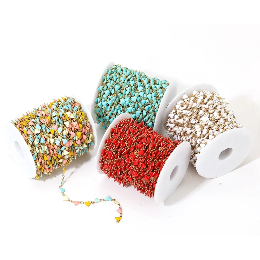 Enamel heart charm chains on spools in teal, red, and gold-tone white