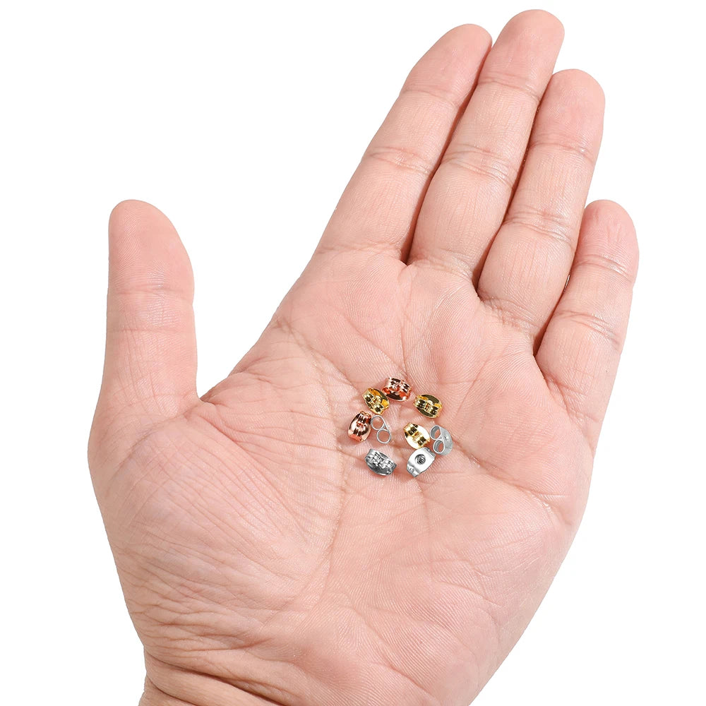 Stainless steel earring back stoppers in mixed finishes, shown in a hand