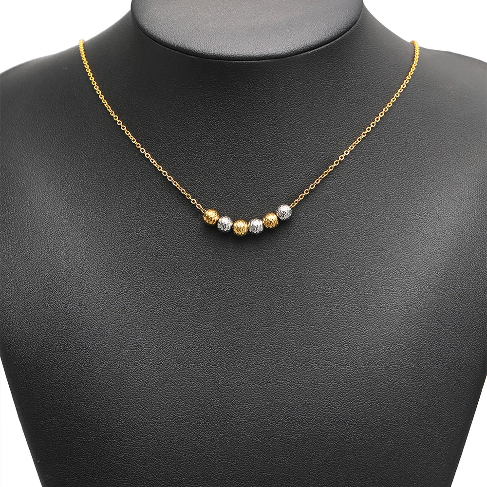 Gold necklace featuring striped cut flower beads spaced along the chain