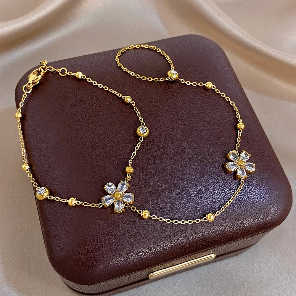 Gold-plated flower charm bracelet with zircon-like petal details on links
