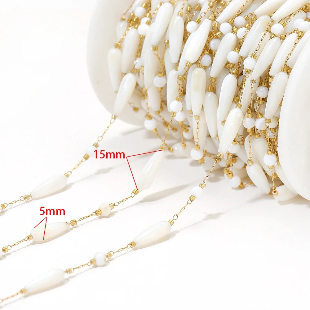 Close-up of white shell-style bead chain with size reference markings and gold links