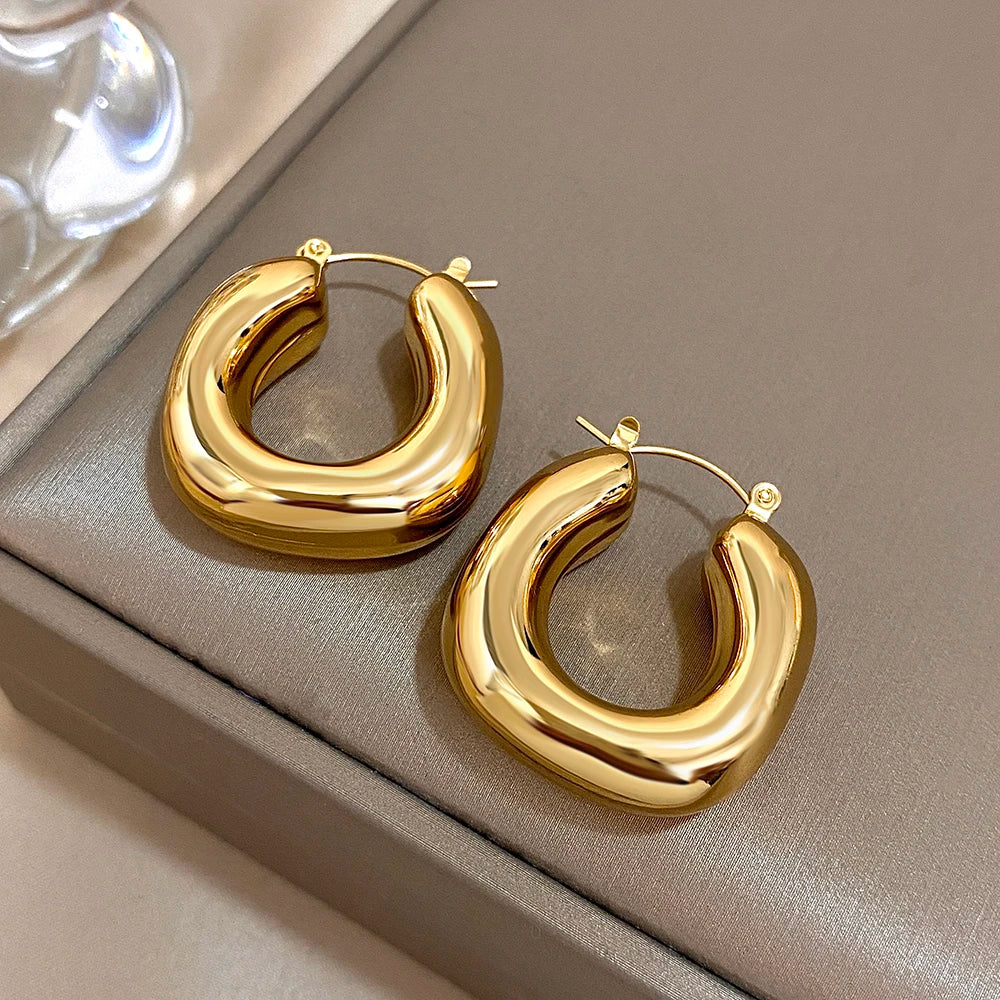 Pair of polished gold-tone U-shaped hoops, shown at an angle