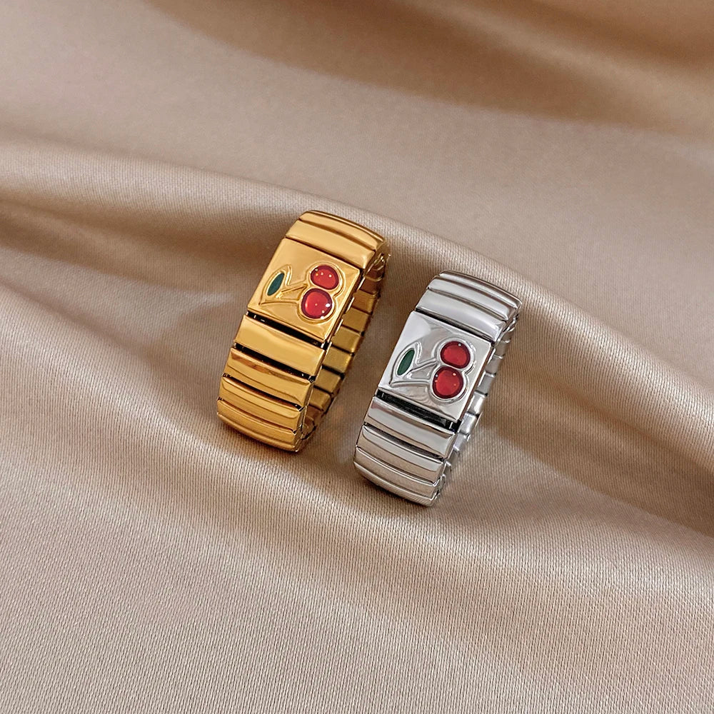 Adjustable watchband-style finger rings in gold and silver with red cherry and green leaf