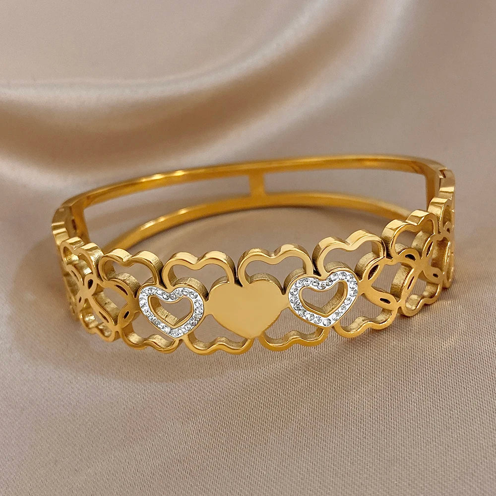 Gold open cuff bangle with scalloped heart charms and clear rhinestone centers