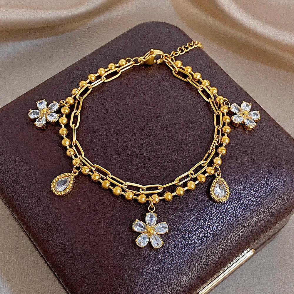Gold-plated link bracelet with crystal flower charms and pear-shaped teardrop pendants