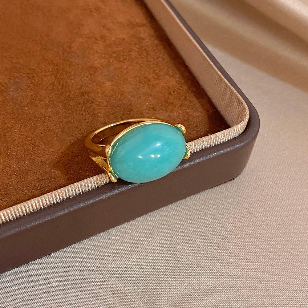Gold-tone ring with turquoise oval stone, angled side view