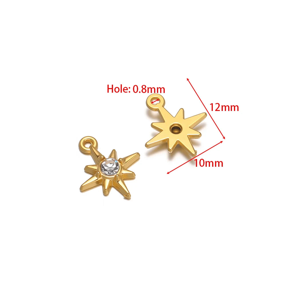 Gold-tone star and starburst charm pendants with rhinestones and hanging loops