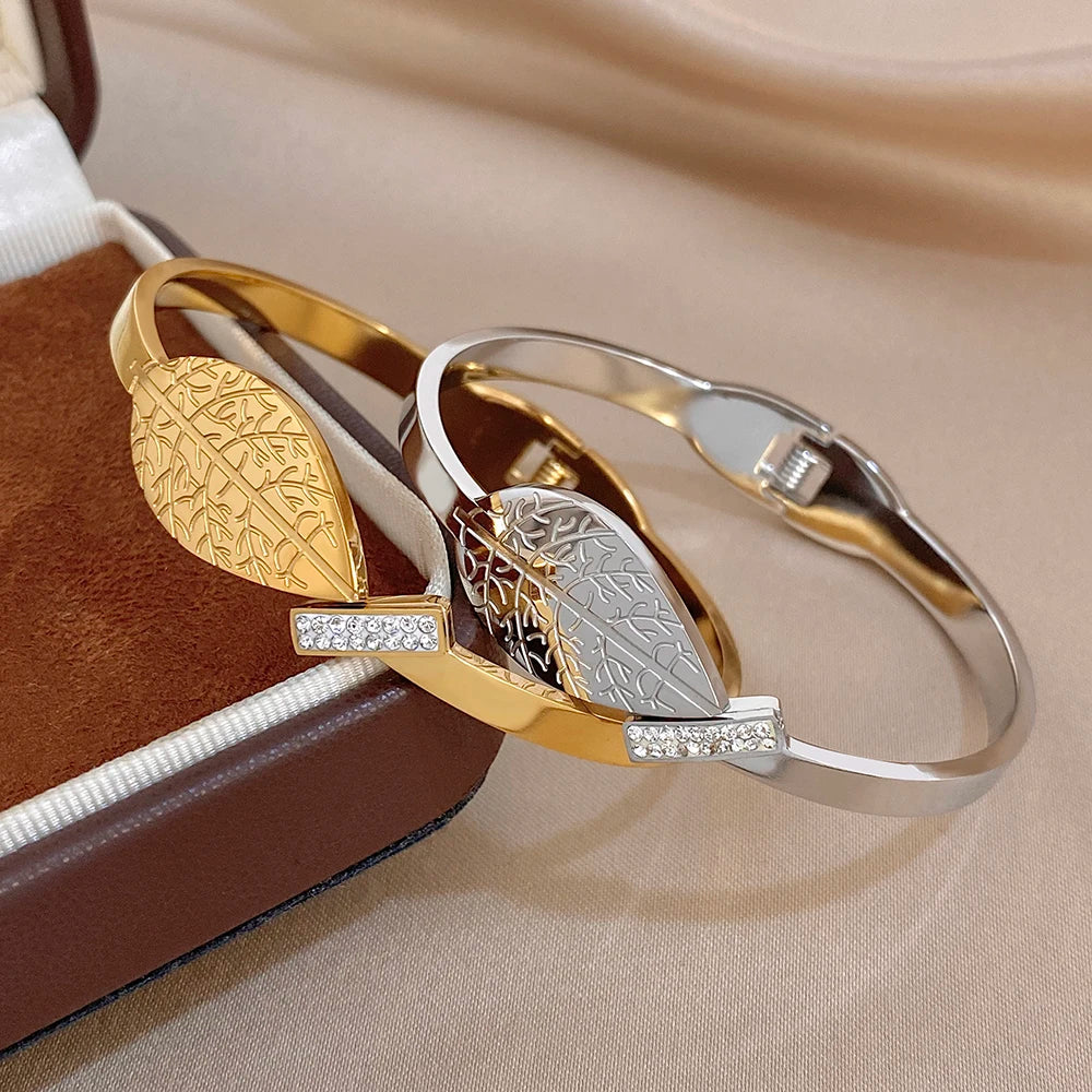 Gold and silver cuff bangles with leaf etching and rhinestone square connector.